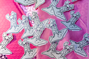Image of multiple Busy Busy stickers in front of a pink background.