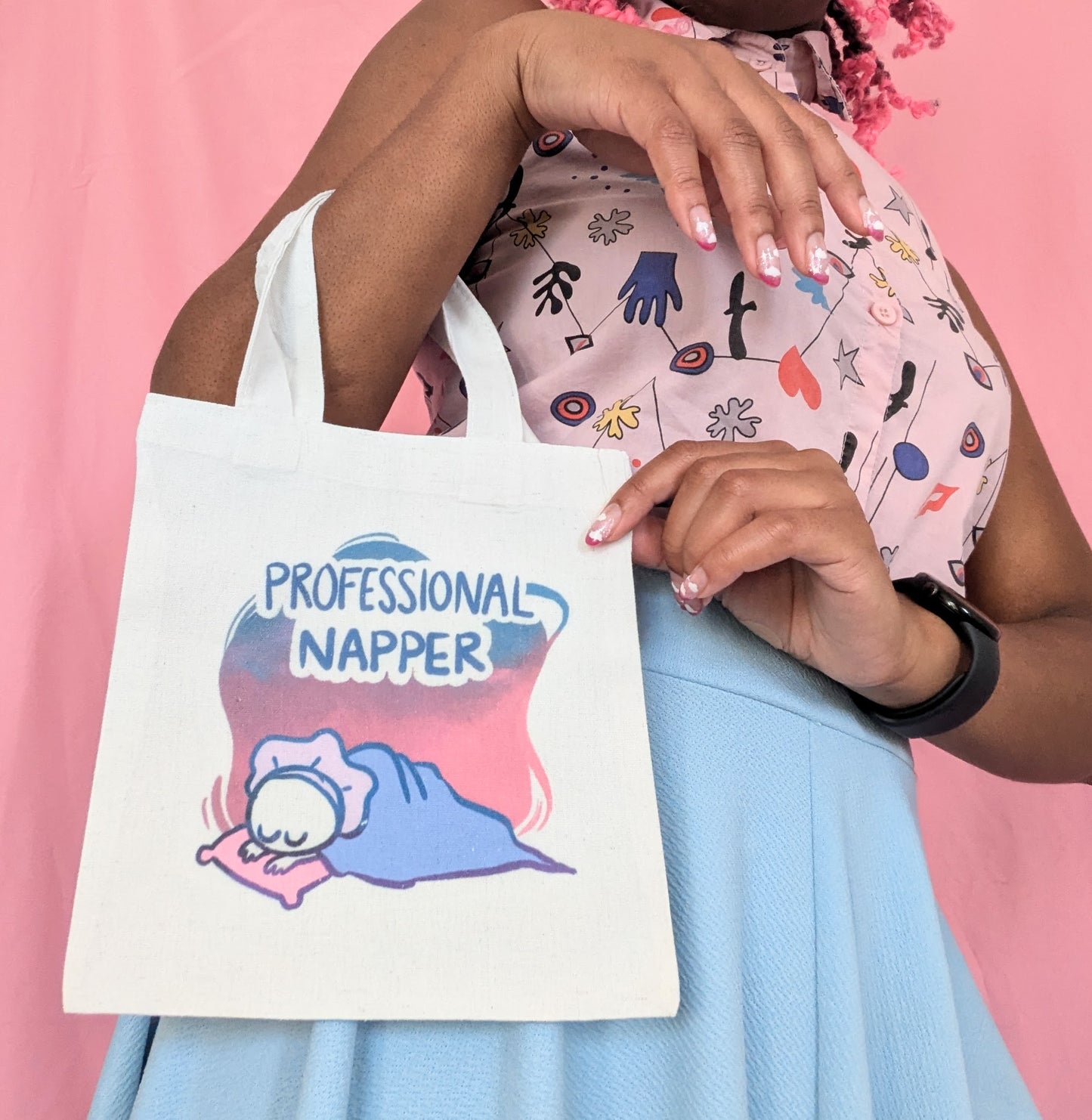 Model holding Professional Napper small tote bag on their arm, with their other hand holding the top corner of the bag.