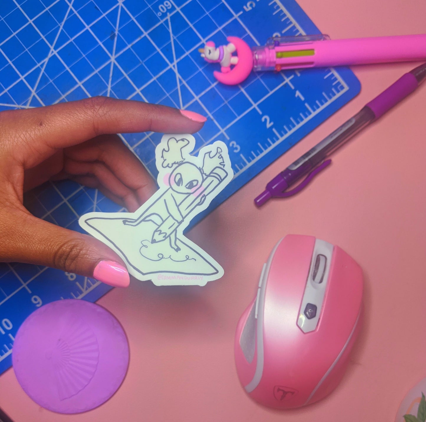 Image of Busy Busy sticker, being held in front of a pink and blue background.